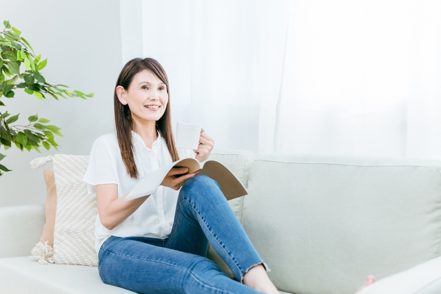 枕に持たれて本を読む女性